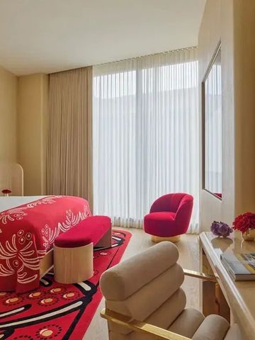 Geräumiges Hotelzimmer mit stilvollen, roten Akzenten