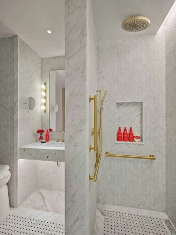 Elegante Dusche mit Marmorverkleidung und goldenen Akzenten