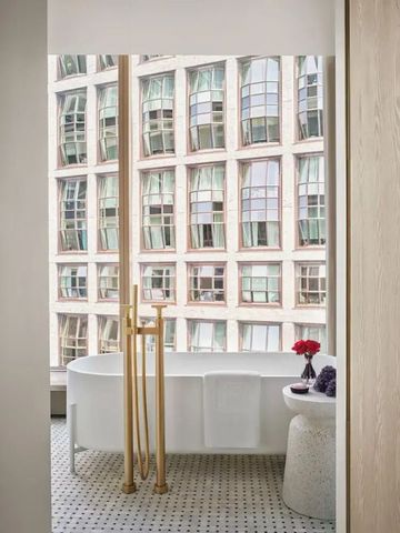 Freistehende Badewanne mit Aussicht auf moderne Architektur