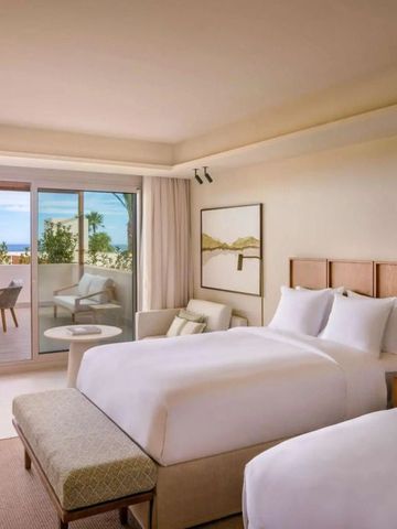 Zweibettzimmer mit Balkonblick auf die Küste.