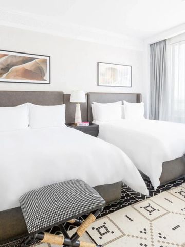 Helles Zimmer mit zwei Doppelbetten und eleganter moderner Dekoration