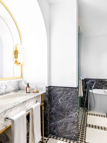 Stilvolles Badezimmer mit Marmorelementen und großem Spiegel