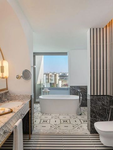 Elegantes Badezimmer mit freistehender Badewanne und Marmorakzenten