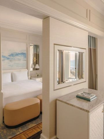 Elegante Junior Suite mit künstlerischer Wandgestaltung und Seeblick