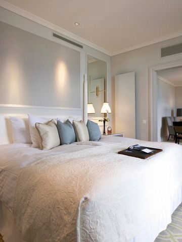 Elegantes Gästezimmer mit großem Bett und Kissen im Fairmont Le Montreux Palace