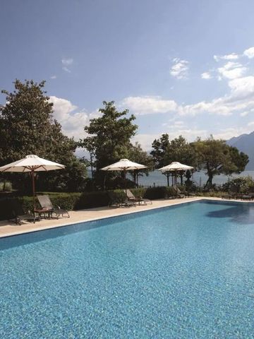 Hotelpool mit Blick auf Berge und Bäume unter blauem Himmel