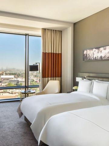 Modernes Doppelzimmer mit Panoramafenster und Blick auf die Stadt