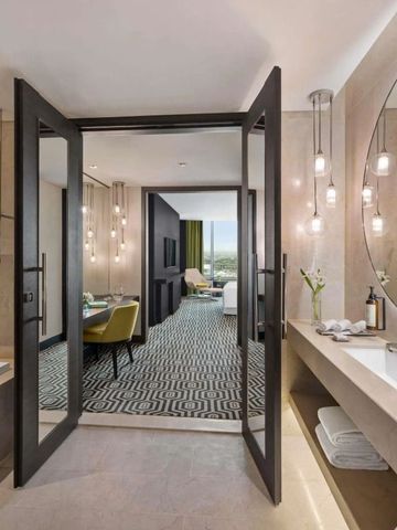 Blick vom Badezimmer zu einem eleganten Hotelzimmer mit modernen Details