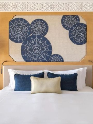 Bett mit kunstvollen blauen Verzierungen an der Kopfwand