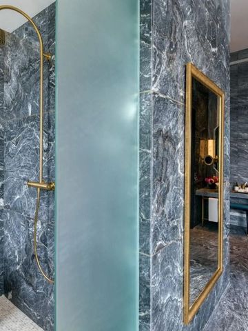 Moderne Dusche mit goldenen Akzenten und dunkelgrauen Wänden