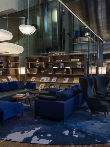 Luxuslounge mit stilvollen Möbeln und Bücherregalen in einer exklusiven Hotelatmosphäre