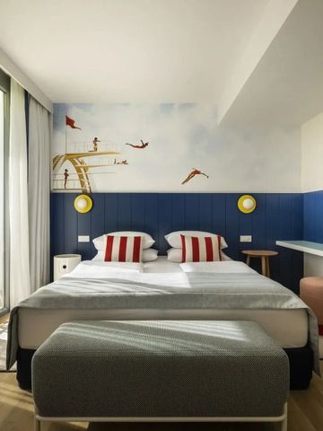 Buntes Hotelzimmer mit Balkon und fröhlicher Wandgestaltung