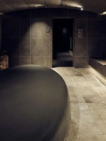 Moderne Wellness-Oase mit dunklen Fliesen und minimalistischen Design