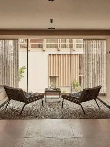 Einladende Lounge mit großen Glasfenstern und stilvollen Sitzen