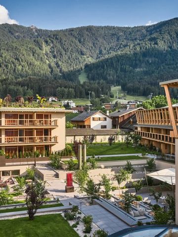 Außenansicht des Hotels mit alpiner Landschaft und moderner Architektur.