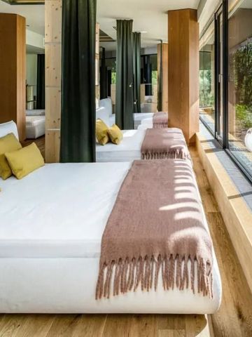 Geräumige Suite mit bodentiefen Fenstern und moderner Einrichtung in warmen Tönen