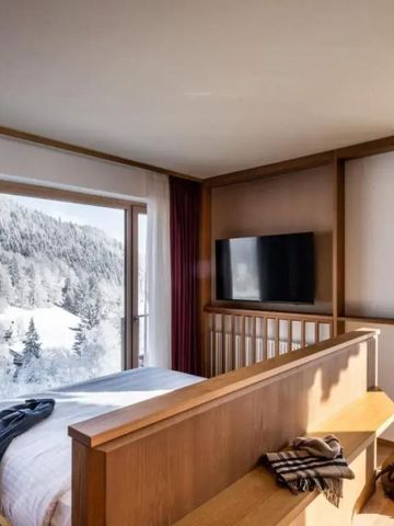 Zimmer mit großem Fenster und beeindruckendem Blick auf verschneite Berge