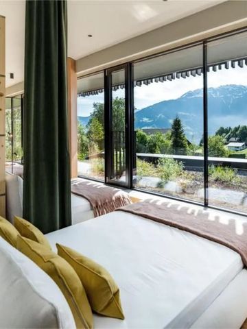 Suite mit großen Fenstern und Bergblick. Moderne Dekoration und minimalistisches Design.