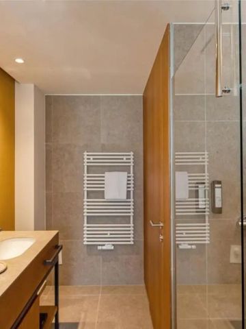 Modernes Badezimmer mit Doppelwaschbecken und großer Dusche in neutralen Tönen.