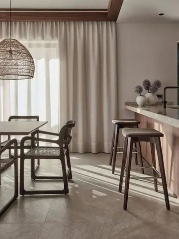 Elegante Küchenzeile mit moderner Holzbar und stilvollen Essmöbeln