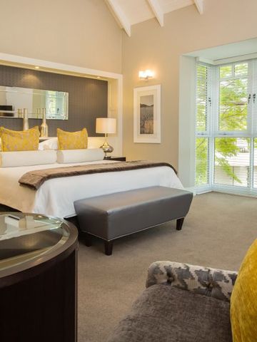 Geräumiges Hotelzimmer mit großem Bett und modernen Möbeln.