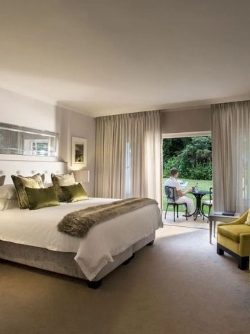 Luxuriöses Zimmer mit Blick auf den Garten durch große Fenster.