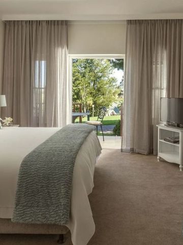 Lichtdurchflutetes Hotelzimmer mit Ausblick auf den grünen Garten