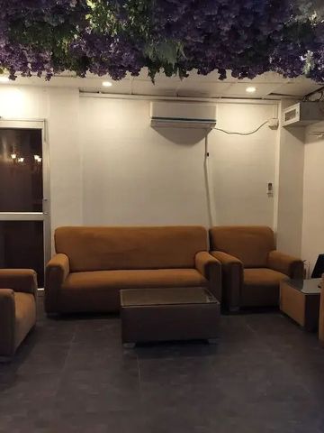 Lobby mit braunen Sofas und lila Blumendekor an der Decke