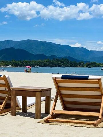 Strand mit Liegestühlen und Blick auf das Meer und Berge