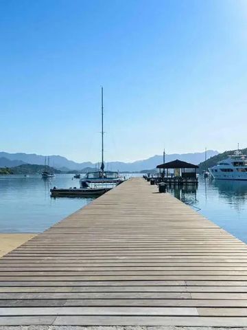 Langer Holzsteg mit Yachten im ruhigen Wasser