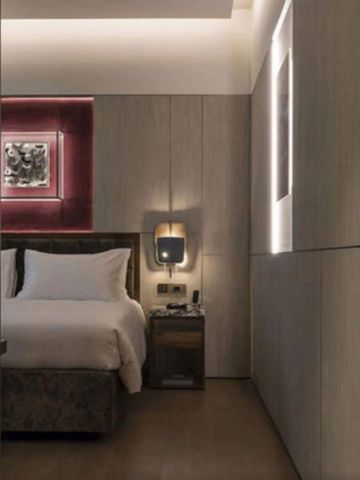 Elegantes Hotelzimmer mit kunstvoller Wandbeleuchtung und luxuriösem Bett