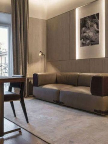 Gemütlicher Wohnbereich mit Sofa und hellem Fenster im Hotelzimmer.