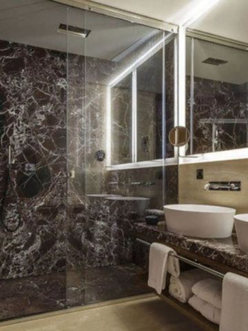 Dusche mit gläserner Trennwand und Marmordesign im eleganten Badezimmer.
