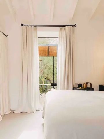 Elegantes Schlafzimmer mit großen Fenstern und weißen Vorhängen