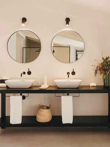 Doppelwaschtisch mit runden Spiegeln vor neutralem Hintergrund