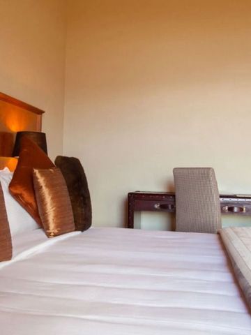 Gemütliches Schlafzimmer mit Doppelbett und Schreibtisch, warme Ausstattung