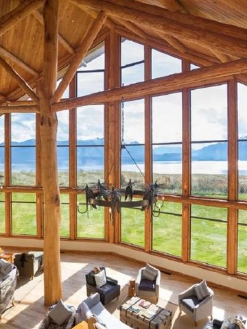 Weiträumige Fensterfront mit bequemen Sitzgelegenheiten und Aussicht auf Berge.