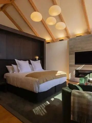 Gemütliches Schlafzimmer mit grünen Sesseln und Holzakzenten