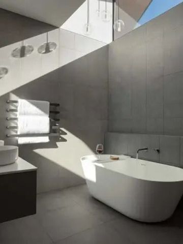 Modernes Badezimmer mit freistehender Badewanne und Tageslicht.