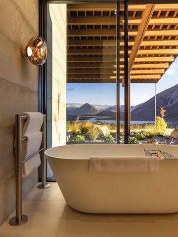 Badezimmer mit freistehender Wanne und weitläufigem Bergblick.