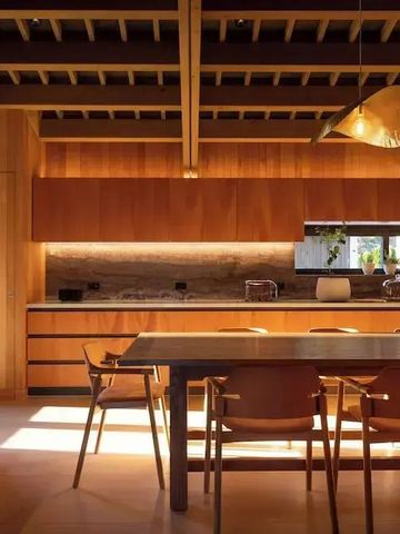 Warme Holzküche mit Esstisch und modernen Leuchten