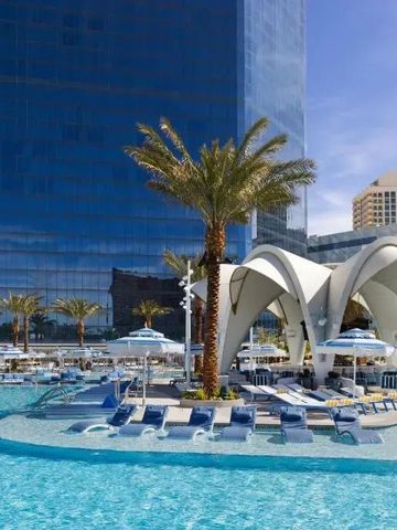 Infinity-Pool umgeben von Palmen und eleganten Liegen vor moderner Architektur.