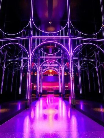 Lila beleuchteter moderner Hotelflur mit spiegelnder Decke im Fontainebleau Las Vegas