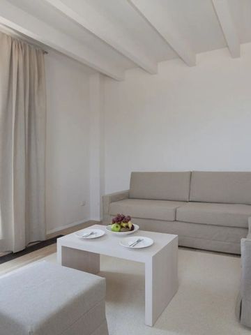 Helles Wohnzimmer mit Sofa und Couchtisch sowie Zugang zur Terrasse