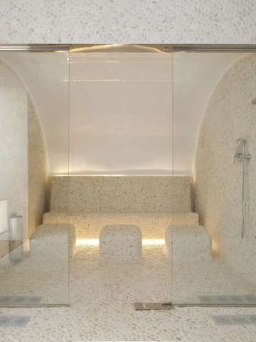 Luxuriöser Spa-Bereich mit Dampfbad aus Mosaikfliesen und eleganter Beleuchtung.