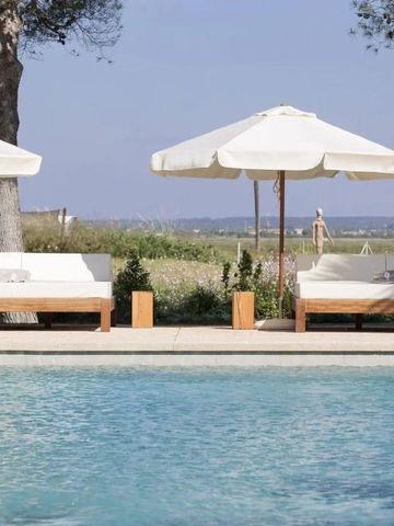 Poolbereich mit bequemen Liegen und Sonnenschirmen vor malerischer Landschaft.