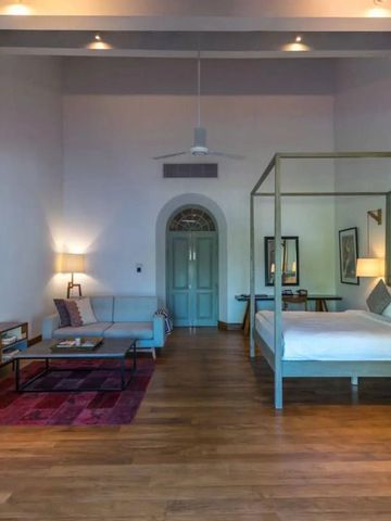 Großzügiges Hotelzimmer mit Holzboden und Sitzecke