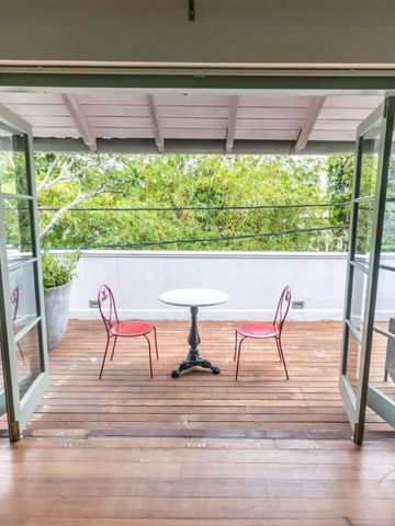 Holzterrasse mit Tisch und Stühlen und grüner Aussicht
