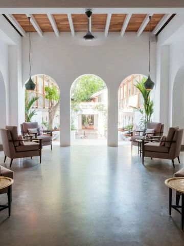 Lichtdurchflutete Hotellobby mit eleganten Sitzmöbeln und hohen Bögen