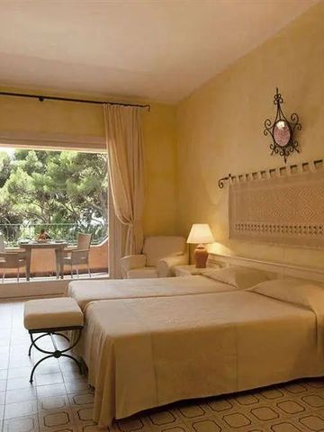 Elegantes Hotelzimmer mit Balkonblick auf grüne Landschaft und bequemen Betten